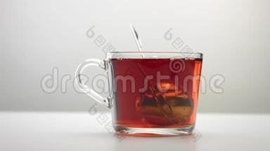 <strong>一个</strong>注入茶的<strong>勺子</strong>缓慢地移动到透明的茶杯里